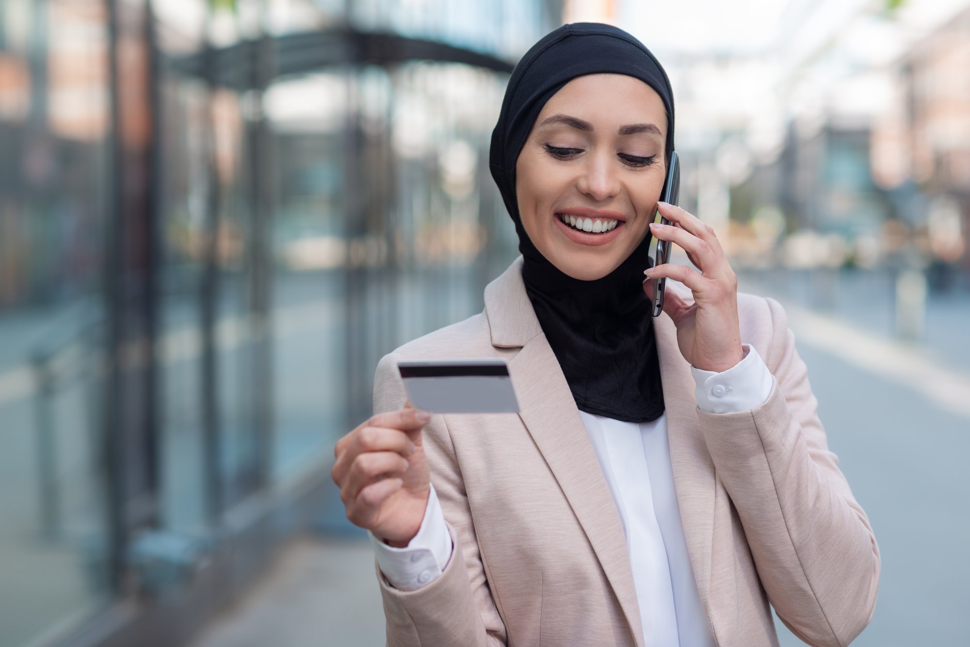 mujer-de-negocios-arabe-hablando-por-telefono-y-sosteniendo-una-tarjeta-de-credito-al-aire-libre mujer-de-negocios-arabe-hablando-por-telefono-y-sosteniendo-una-tarjeta-de-credito-al-aire-libre